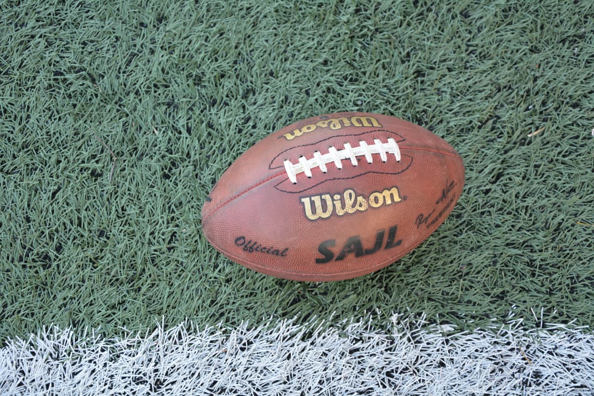 En amerikansk fotboll med amerikanska fotbollsförbundet SAJL:s logo.