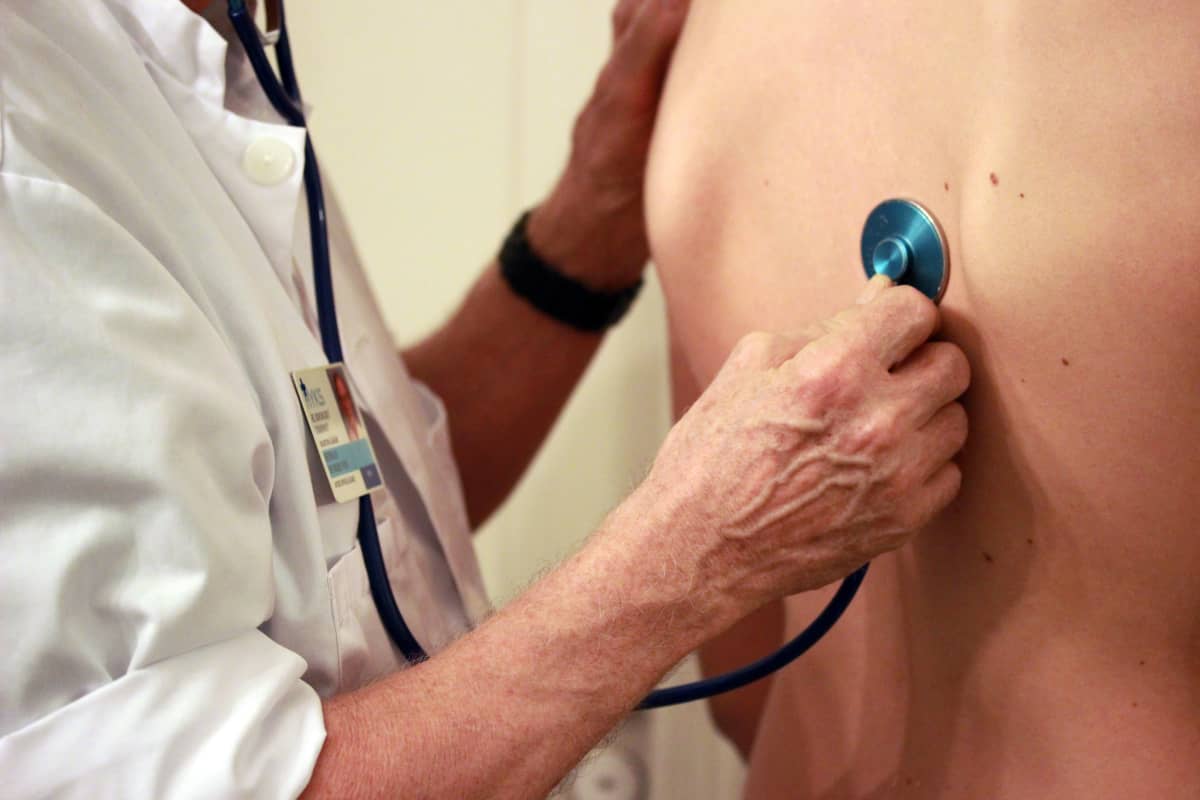 Läkare undersöker patient med stetostop.