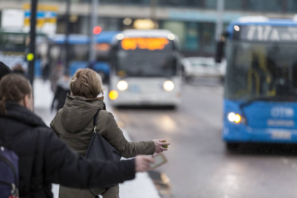 Ihmisiä nousemassa bussin kyytiin Helsingissä.