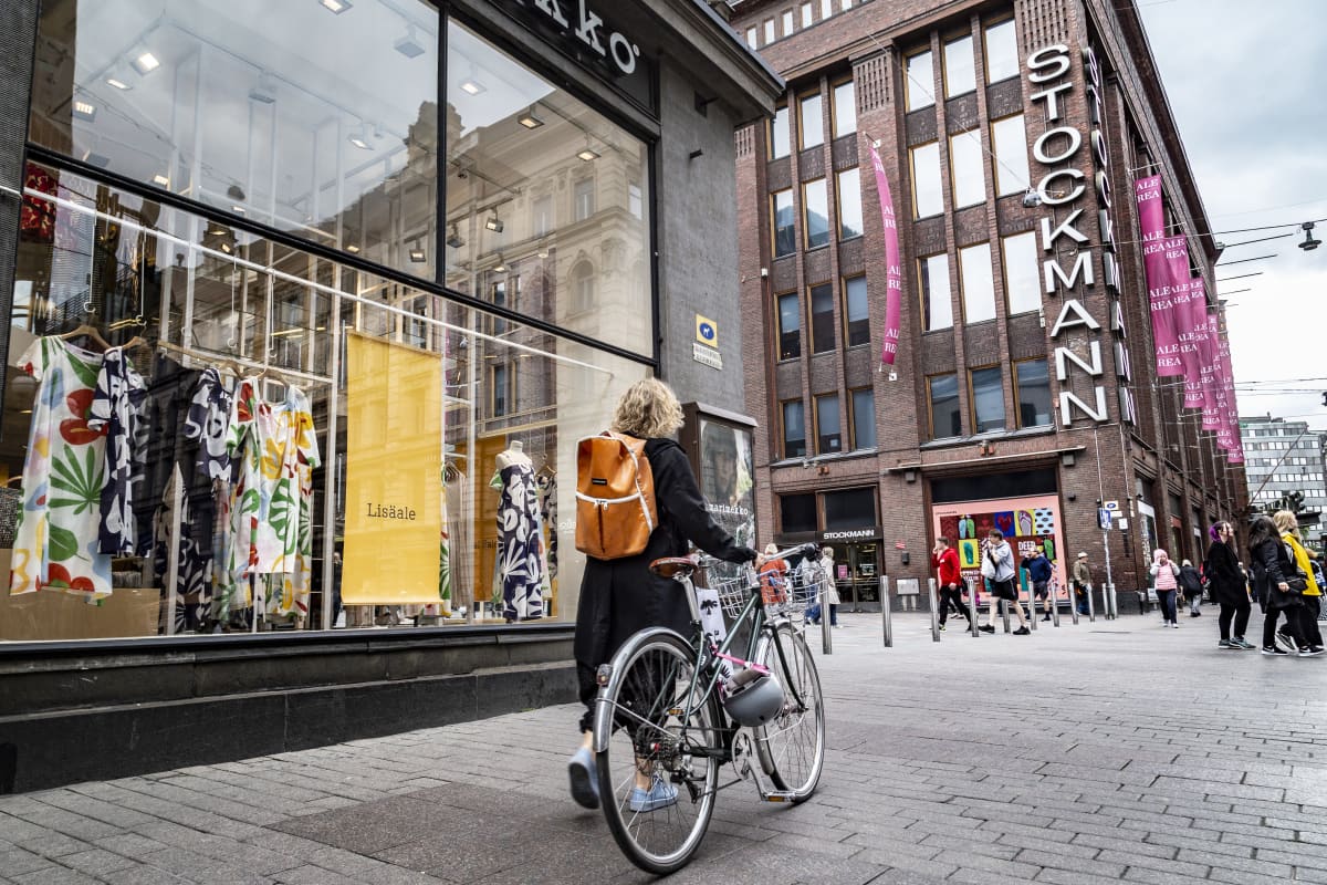 nainen taluttaa polkupyörää Aleksanterinkadulla Stockmannin edessä