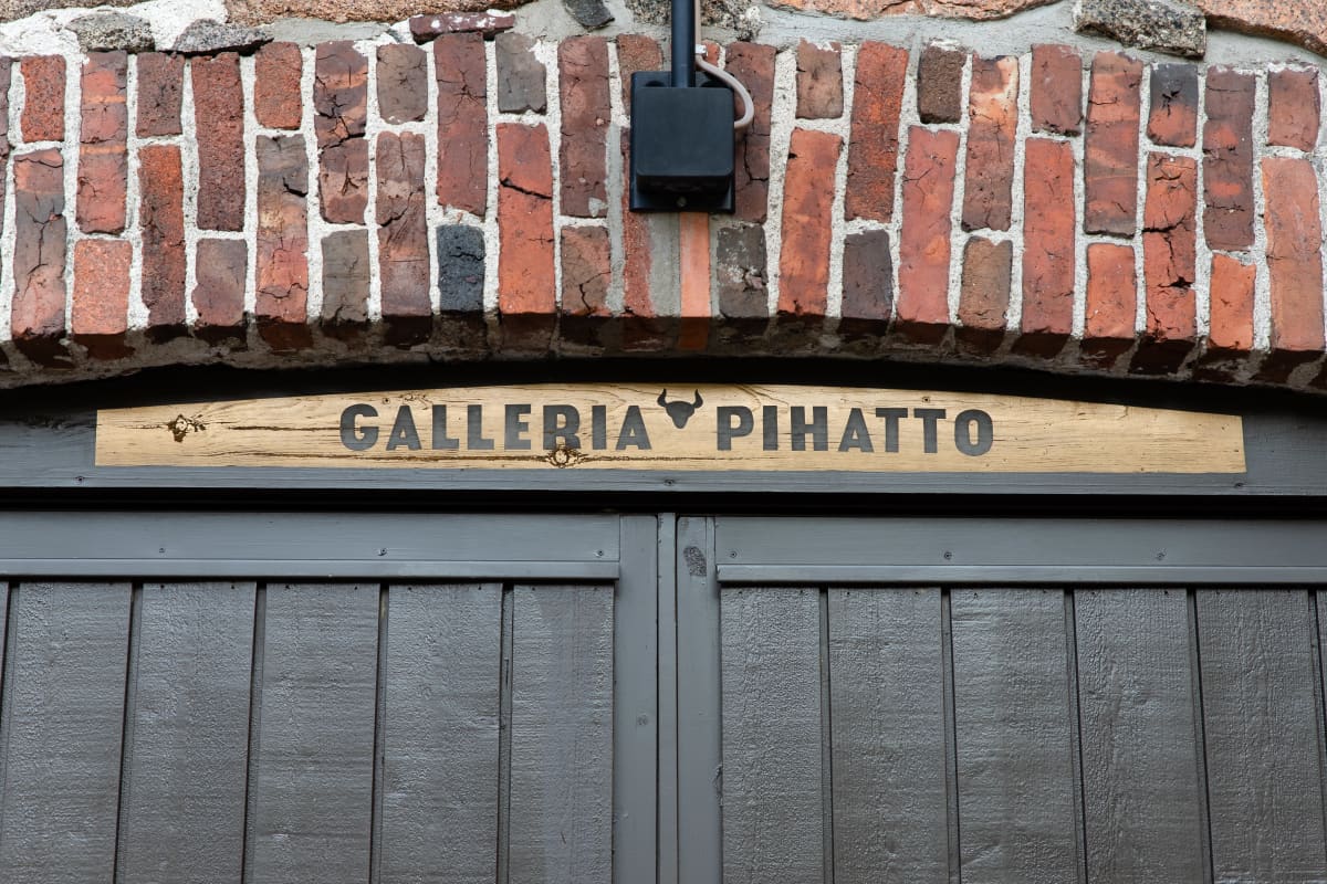 Galleria Pihaton kyltti vanhan Lappeenrannan Pappilan pihatto-rakennuksen seinässä oven yläpuolella.