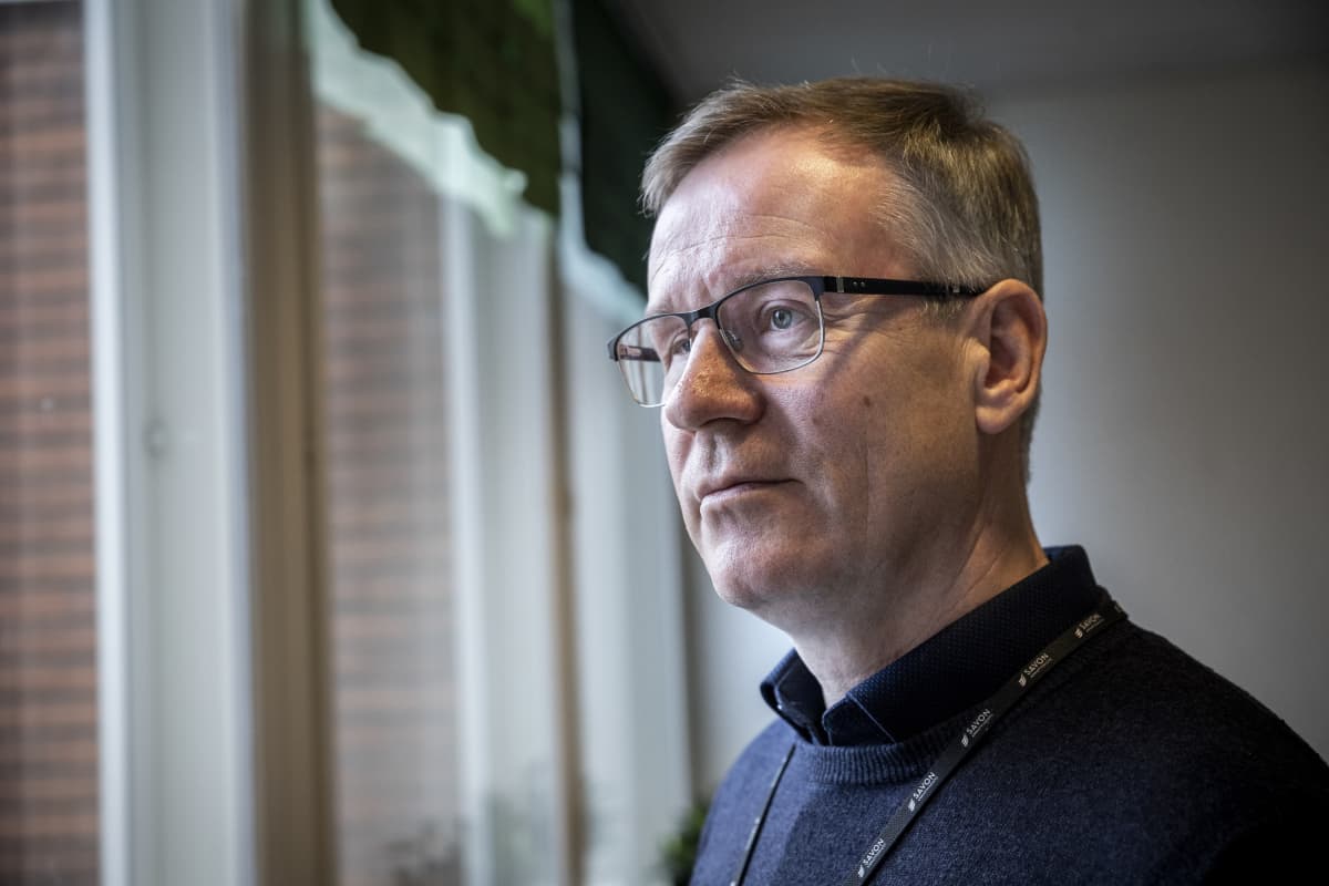 kuntayhtymän johtaja Heikki Helve presidentinkadun oppilaitoksen aulassa katsomassa ikkunasta ulos