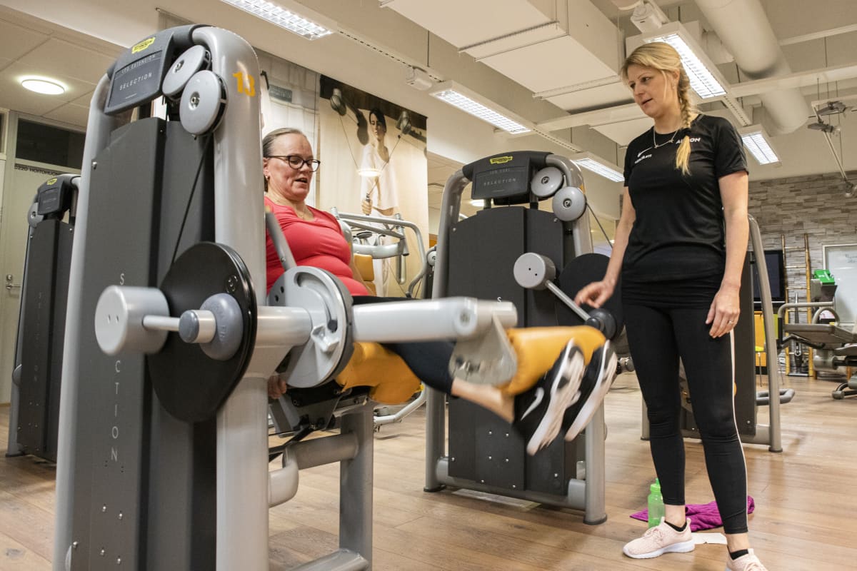 Fysioterapeutti Anni Hupli ohjaamassa Tarja Kaskenviitaa kuntosalilla.
