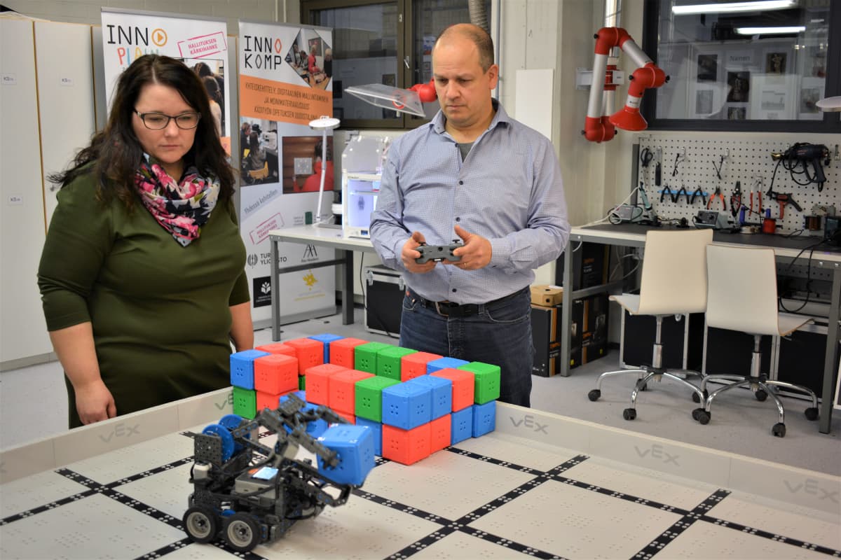 1. vuoden käsityönopettajaksi opiskeleva Heli Mäenpää ja 3. vuoden opiskelija Antti Vepsäläinen Rauman OKL:stä ohjaavat robottinosturia, jollaisia yläkoulun oppilaitakin opetetaan ohjelmoimaan.
