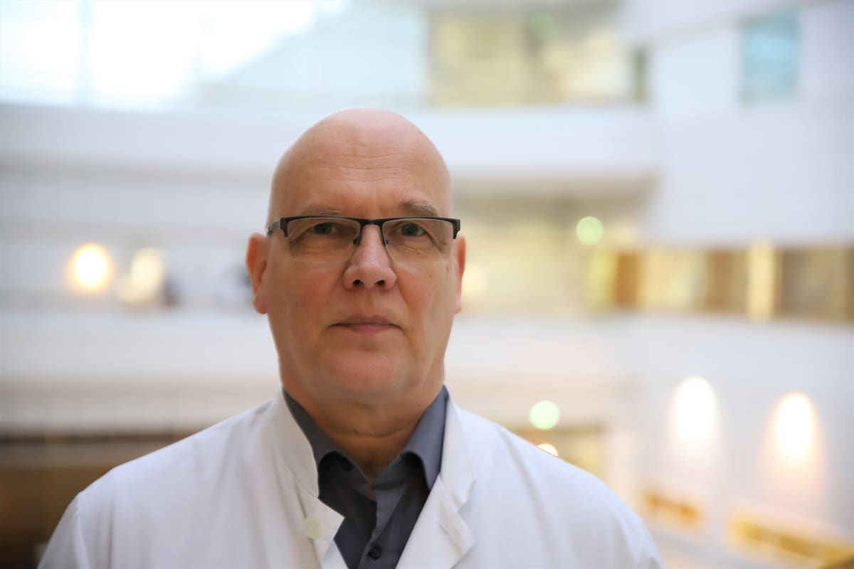 Ylilääkäri Esa Rintala seisoo Turun yliopistollisen keskussairaalan aulassa. 