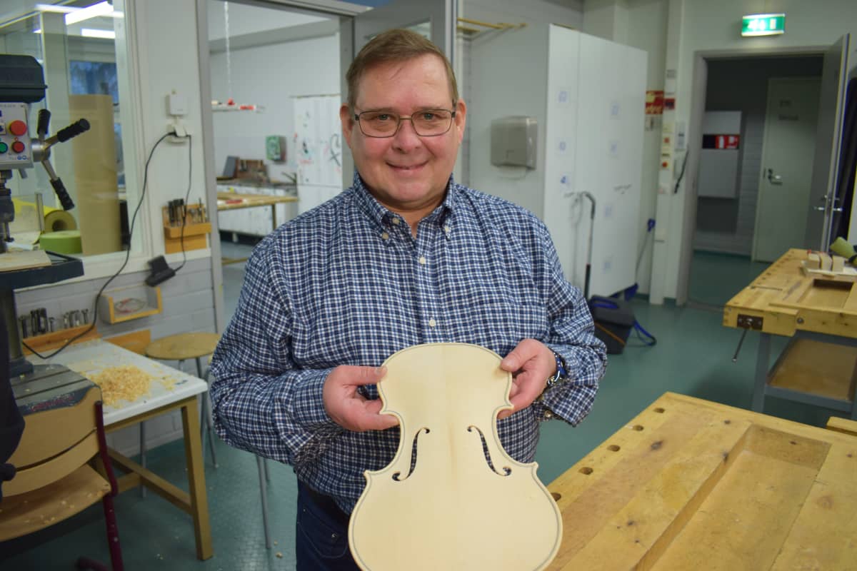 Viulunrakentaja Tapio Vainisto näyttää viulun kantta.