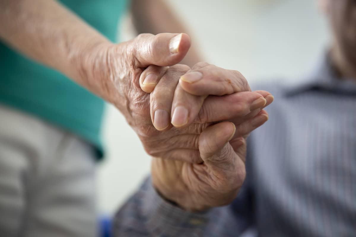 Två personer håller varandra i hand.  