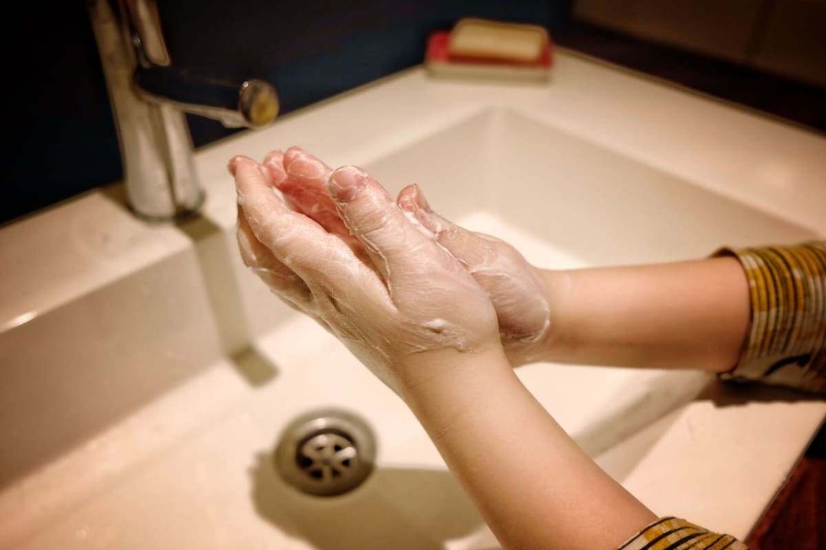 Lapsi pesee käsiään kylpyhuoneessa.