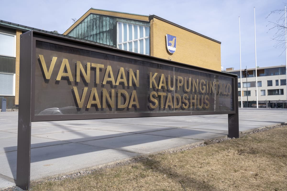 Kyltti jossa lukee Vantaan kaupungintalo. Takana näkyy kaupungintalo jonka seinällä on Vantaan vaakuna.