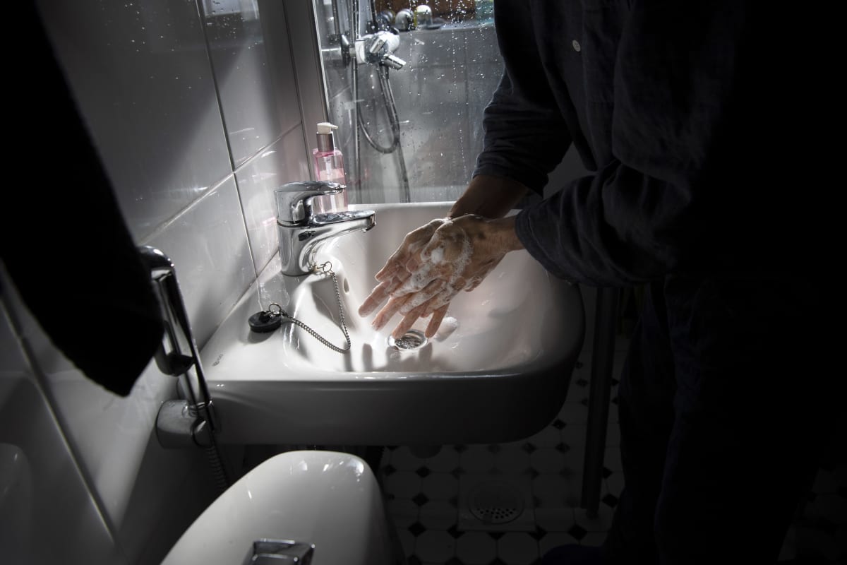 Mies pesee käsiään kylpyhuoneessa.