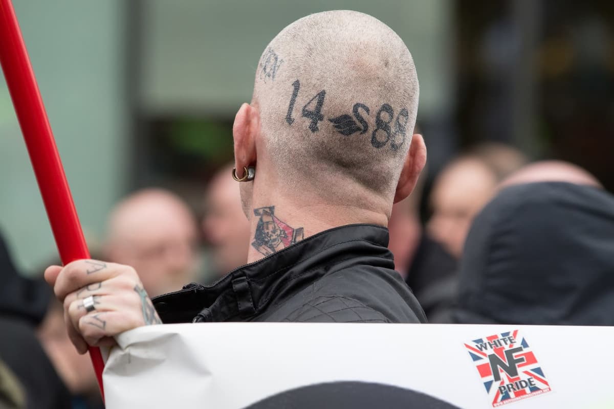 Miehen paljaaksi ajeltuun päähän on tatuoitu uusnatsien symboleja.