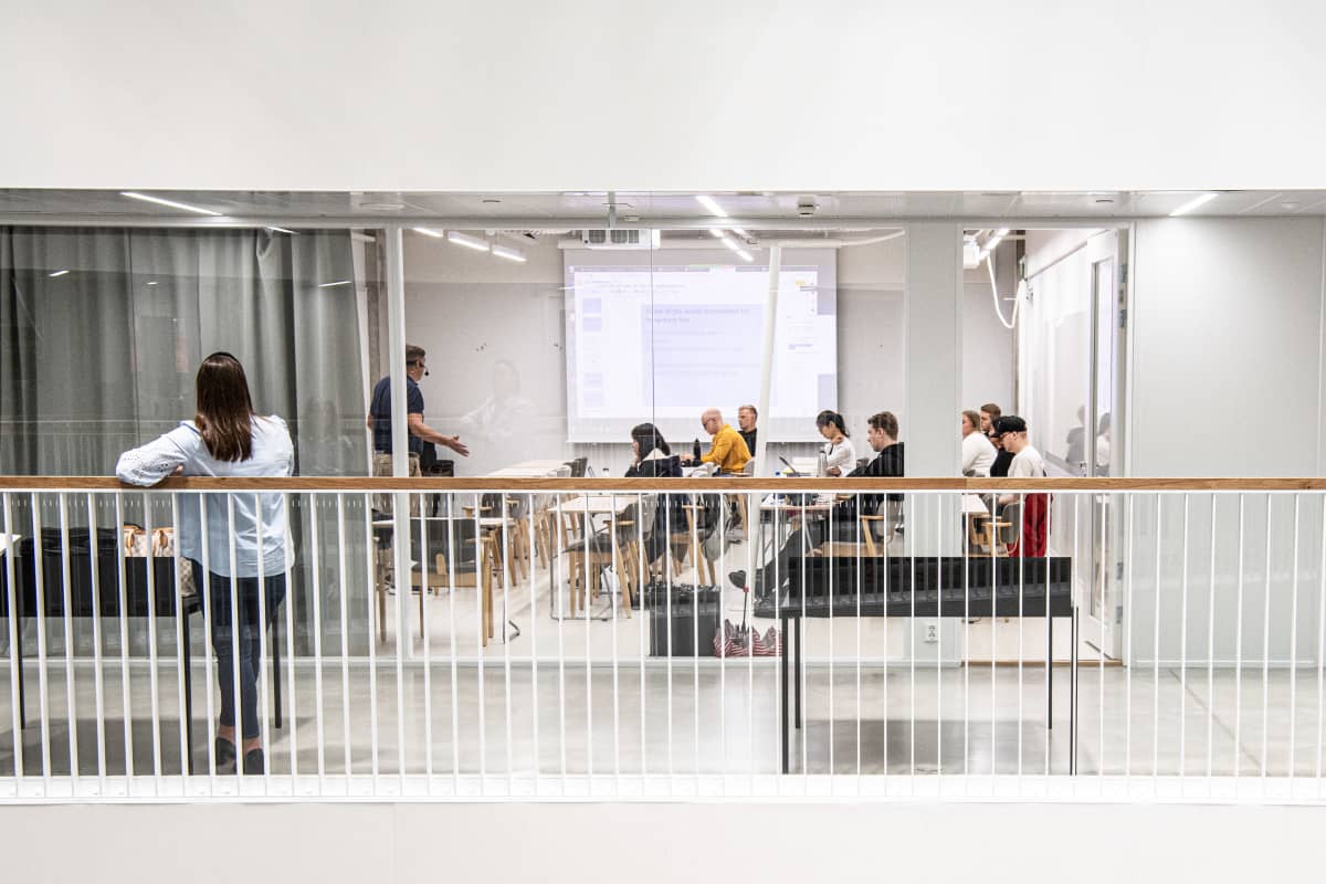 Kesäkurssin opiskelijoita luokkahuoneessa. Etäyhteydellä mukana muita opiskelijoita ympäriä Suomea ja muuta maailmaa.