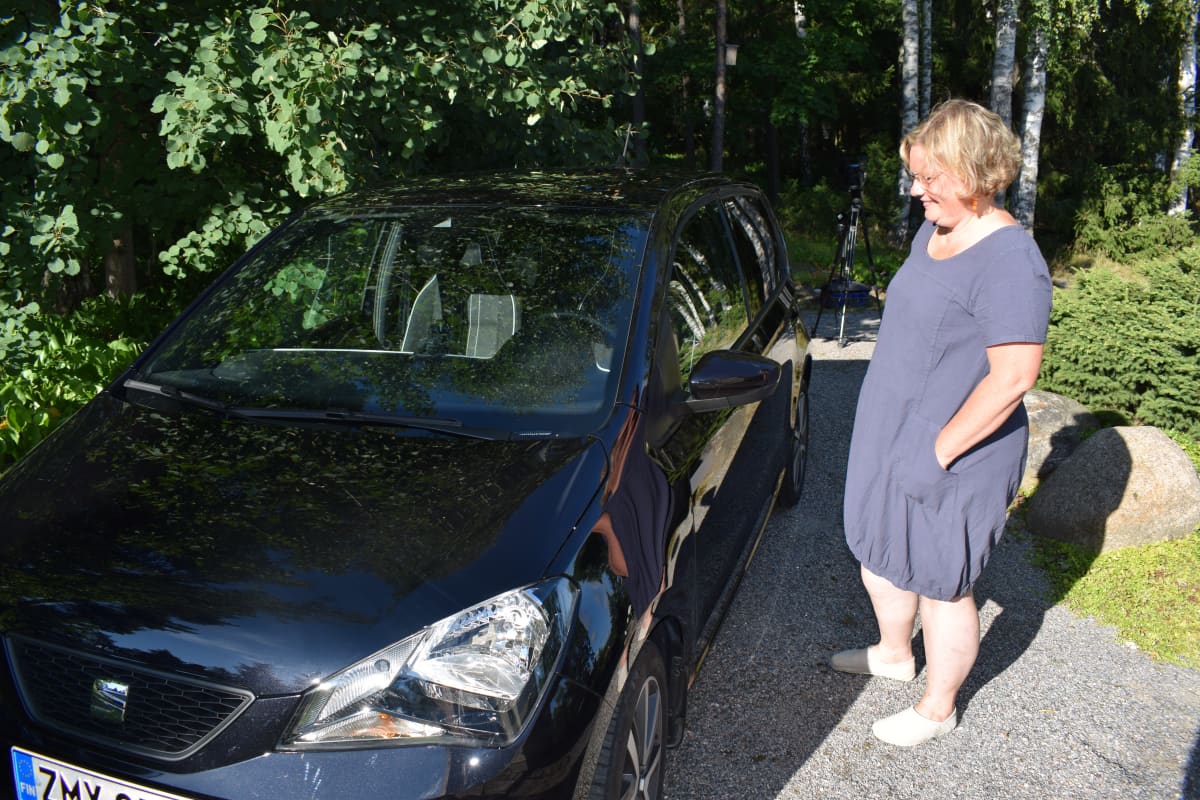 Kirsi Nuutinen katselee Seat Mii-autoaan.