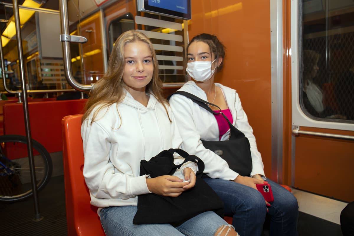 Kaksi nuorta naista metrossa. 