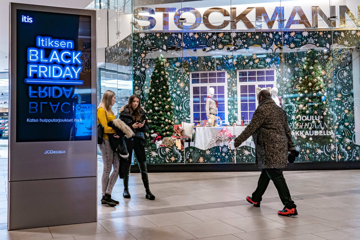 Ihmisiä Stockmannin edessä Black Friday-mainoksen vieressä Itiksessä.