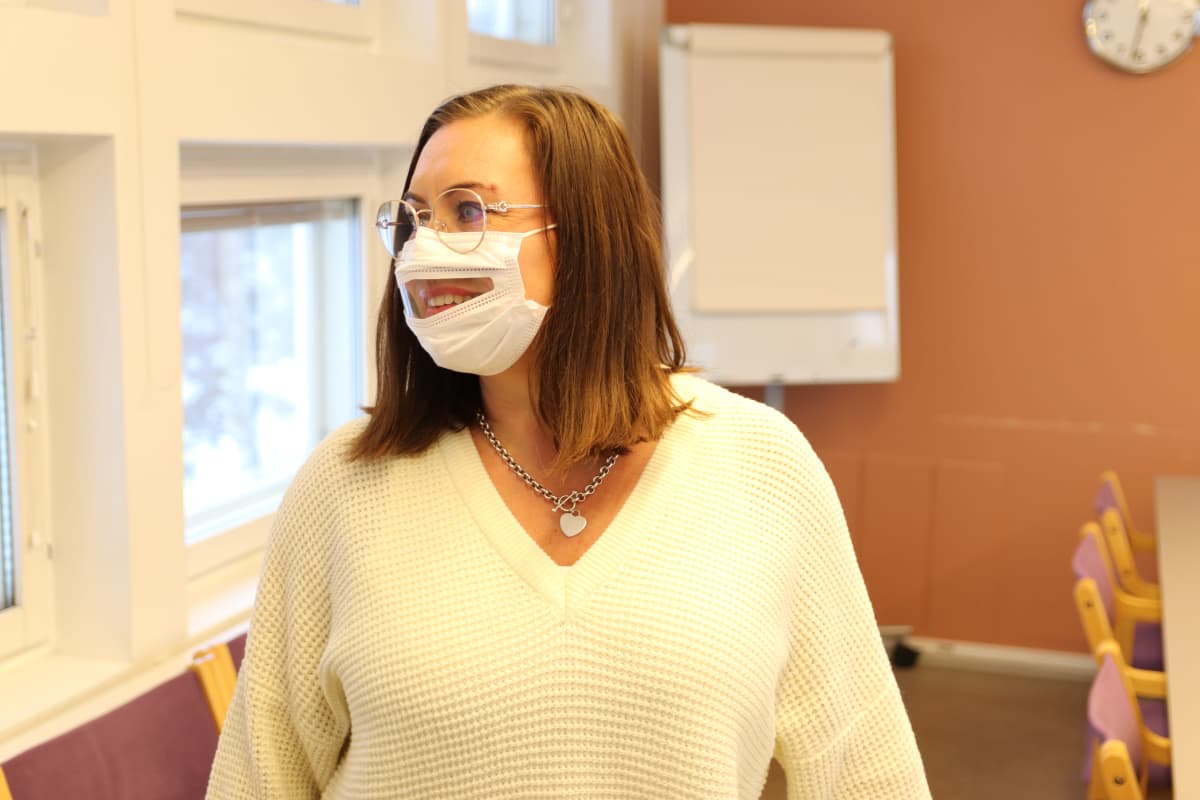 Kuuloliiton toiminnanjohtaja Sanna Kaijanen pitää suun kohdalta ikkunallista maskia yllään.
