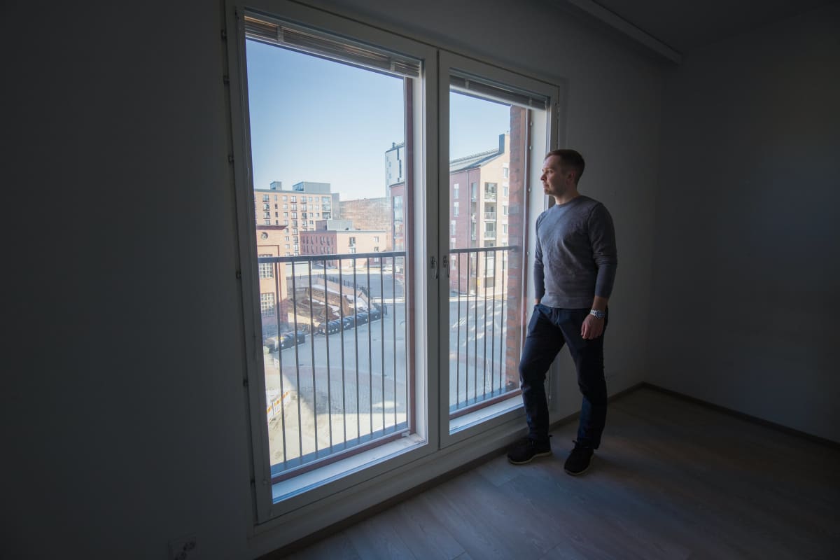 Kiinteistönvälittäjä Tero Tupamäki katselee maisemaa sijoitusasuntonsa ikkunasta.