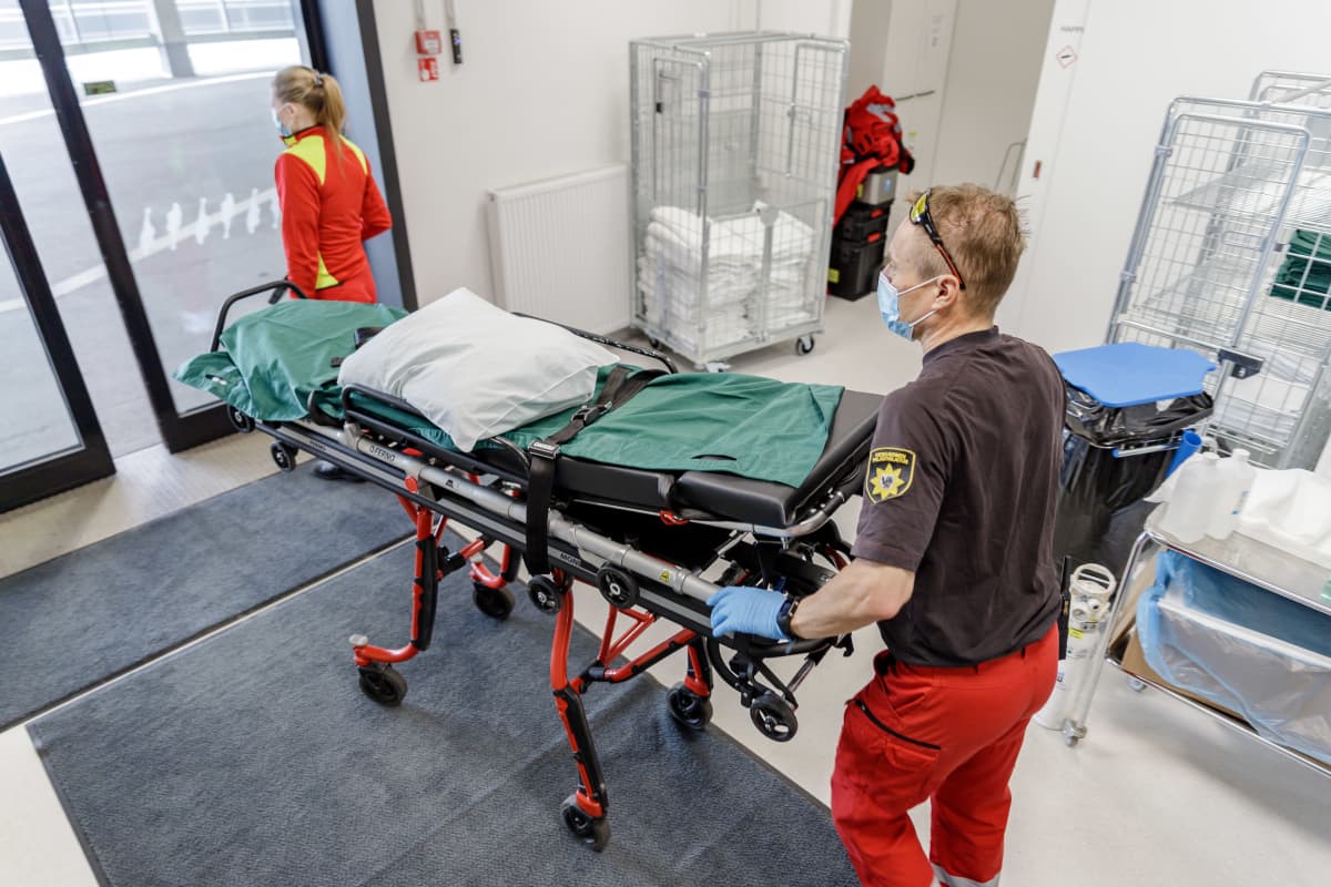 Ambulanssin henkilökunta työntävät tyhjiä paareja Sairaala Novan pävystyksessä.