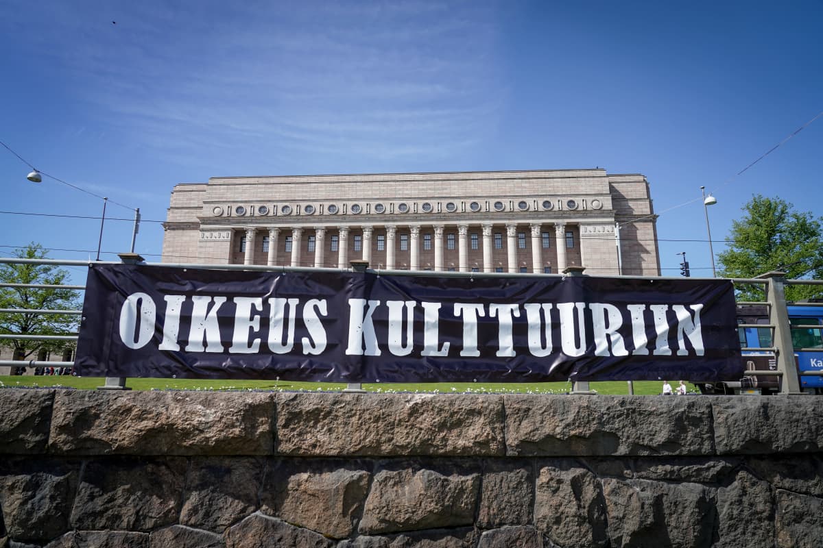 Kulttuurialan mielenilmaus Eduskuntatalon ja Oodin välissä. Kuvassa banderolli jossa lukee "oikeus kulttuuriin".
