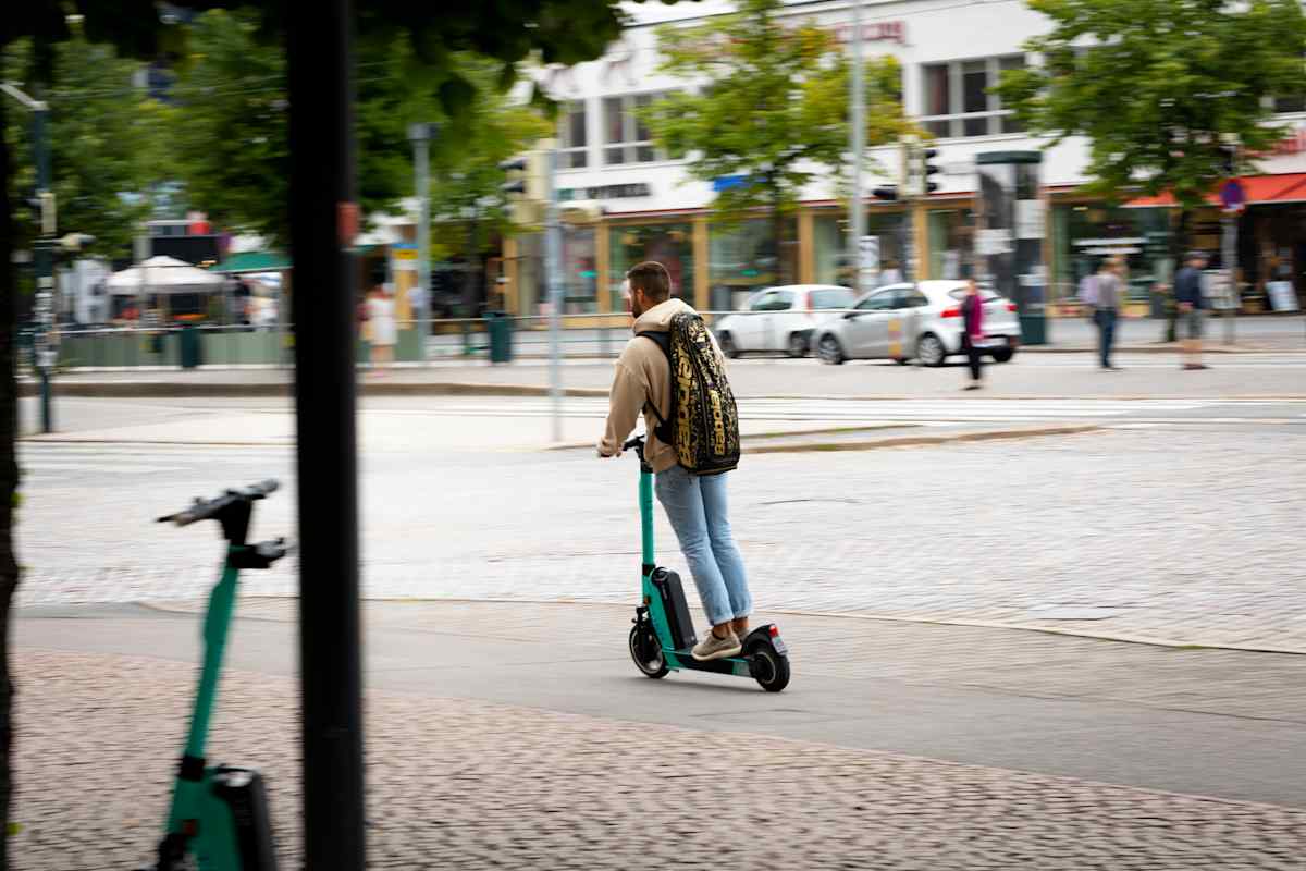 Mies ajaa sähköpotkulaudalla.