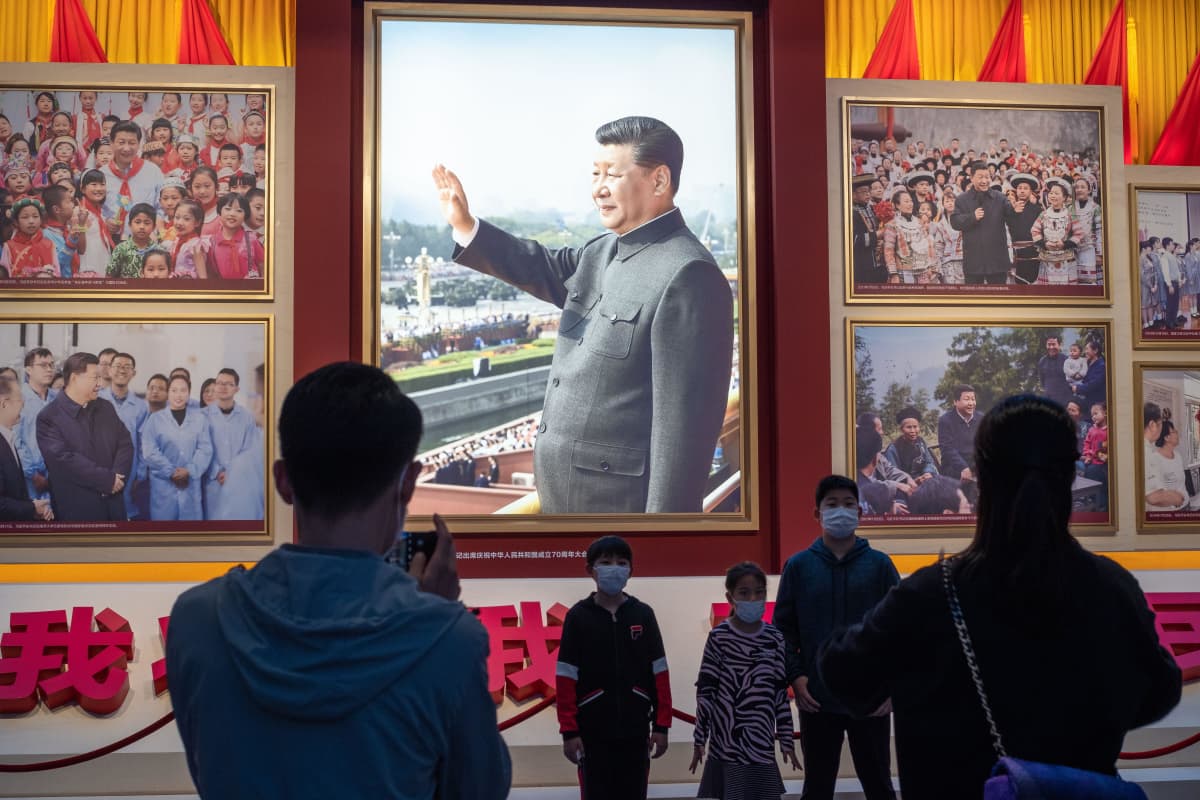Joukko ihmisiä katsoo Xi Jinpingin kuvaa Kiinan kommunistisen puolueen museossa. 