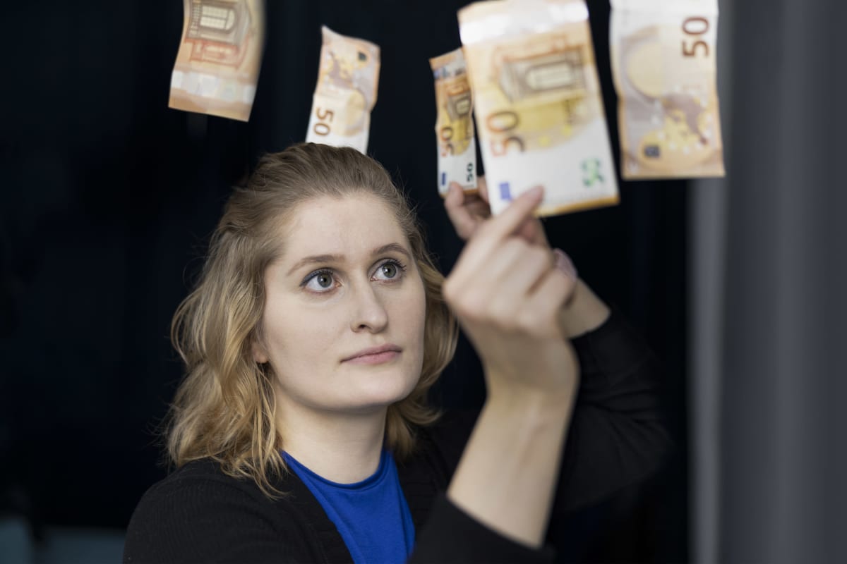 Liisa Salonen poimii viidenkymmenen euron seteteleitä ilmasta.