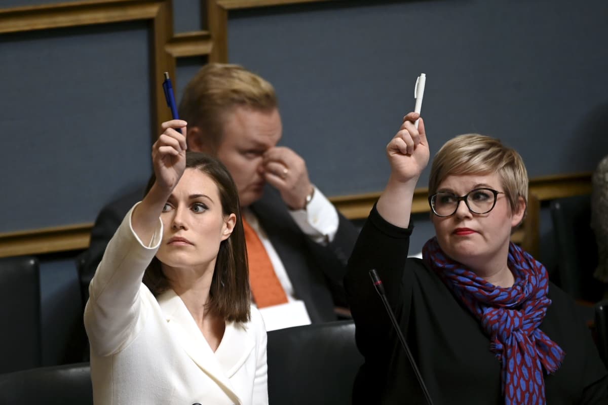 Sanna Marin (vas) ja  Annika Saarikko eduskunnassa.