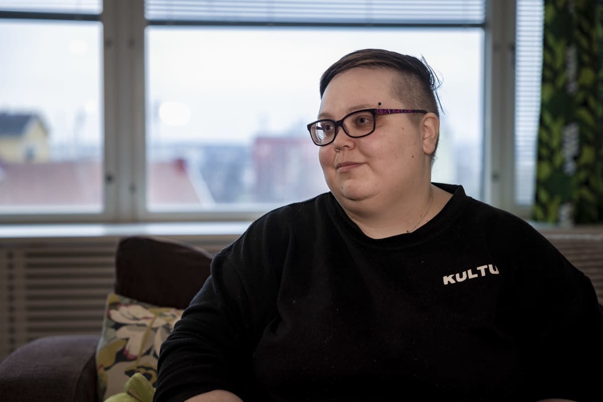 Oululainen muunsukupuolinen Juuli Koskinen istuu sohvalla