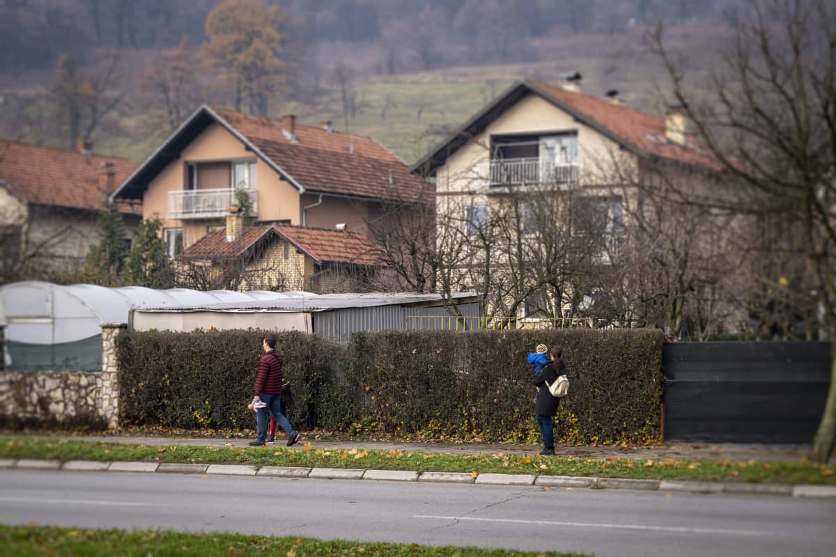 Ihmisiä kävelee Bosniakkien ja Serbien tasavaltojen rajavyöhykkeen läheisyydessä