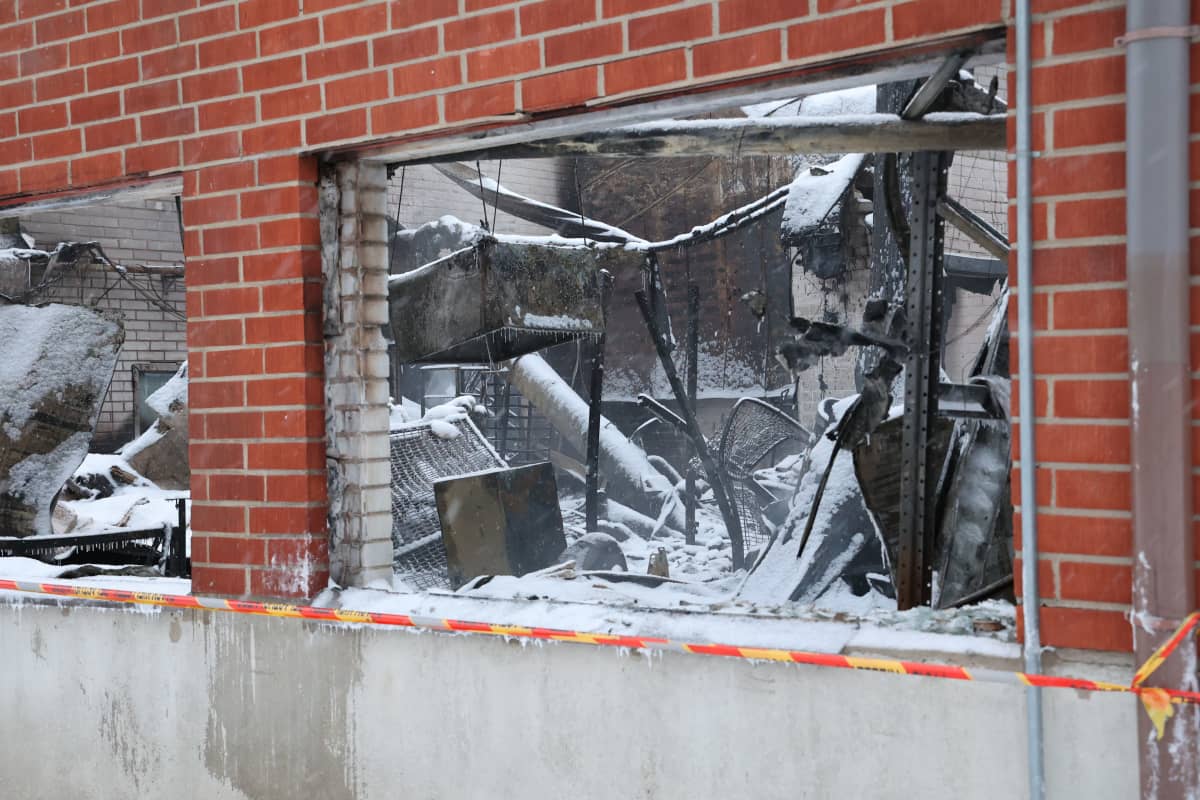 Tuhoutuneen tehtaan ikkunoiden kautta näkyy tuotantotilojen tulipalossa mustuneita laitteistoja. 