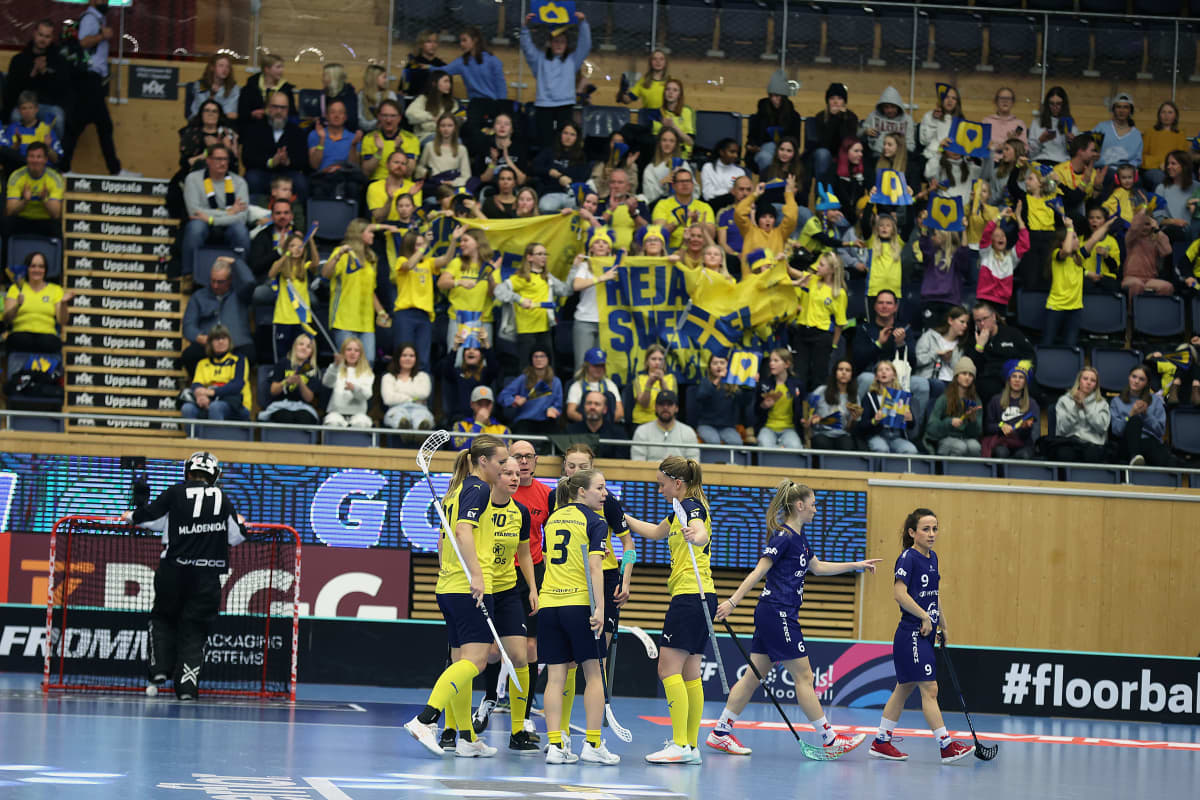 Ruotsin naisten salibandymaajoukkue tuulettaa maalia kasassa. Taustalla faneja.