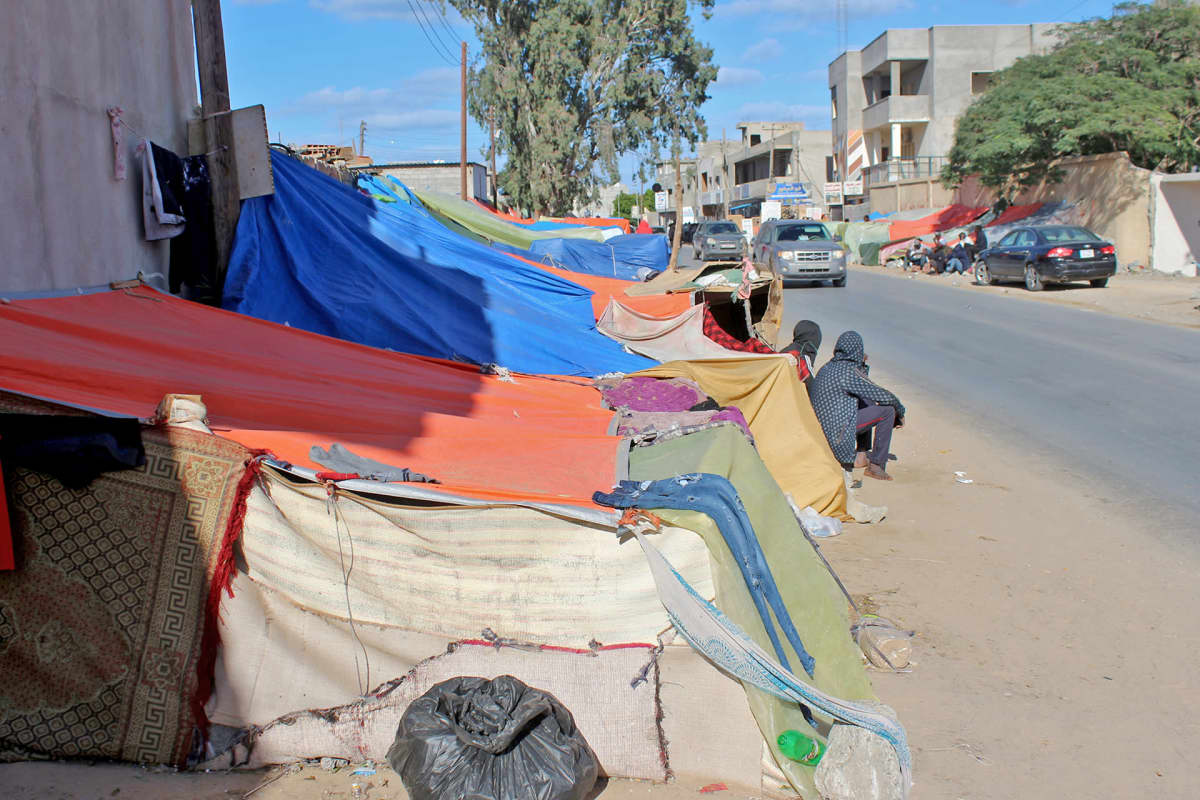 Siirtolaisten kyhäämä leiri kadun varressa Tripolissa.