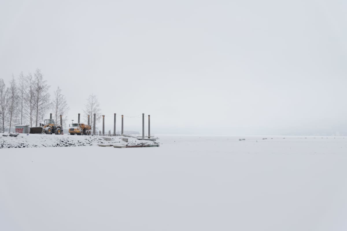 Tampereelle rakennettavan tekosaaren ponttooneja ja työkoneita talvella.