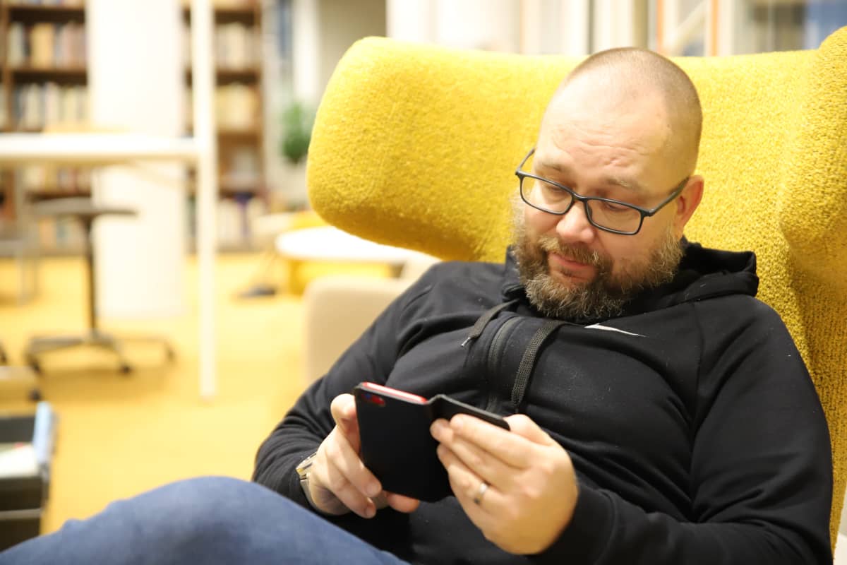 Jukka-Pekka Puro selaa kännykkäänsä.