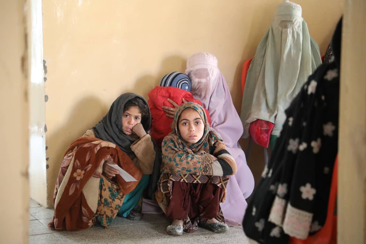Äiti lapsineen odottaa vuoroaan terveysasemalla Etelä-Afganistanissa.