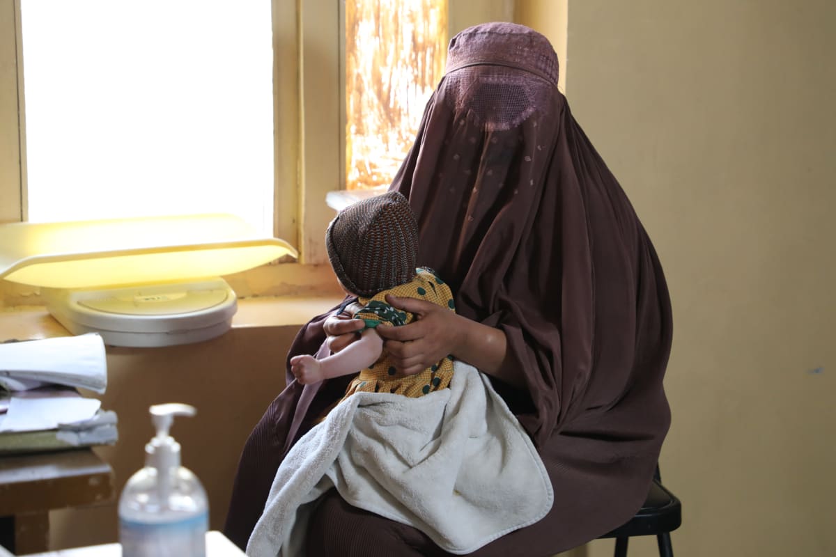 Äiti ja lapsi istuvat terveysasemalla Afganistanissa.