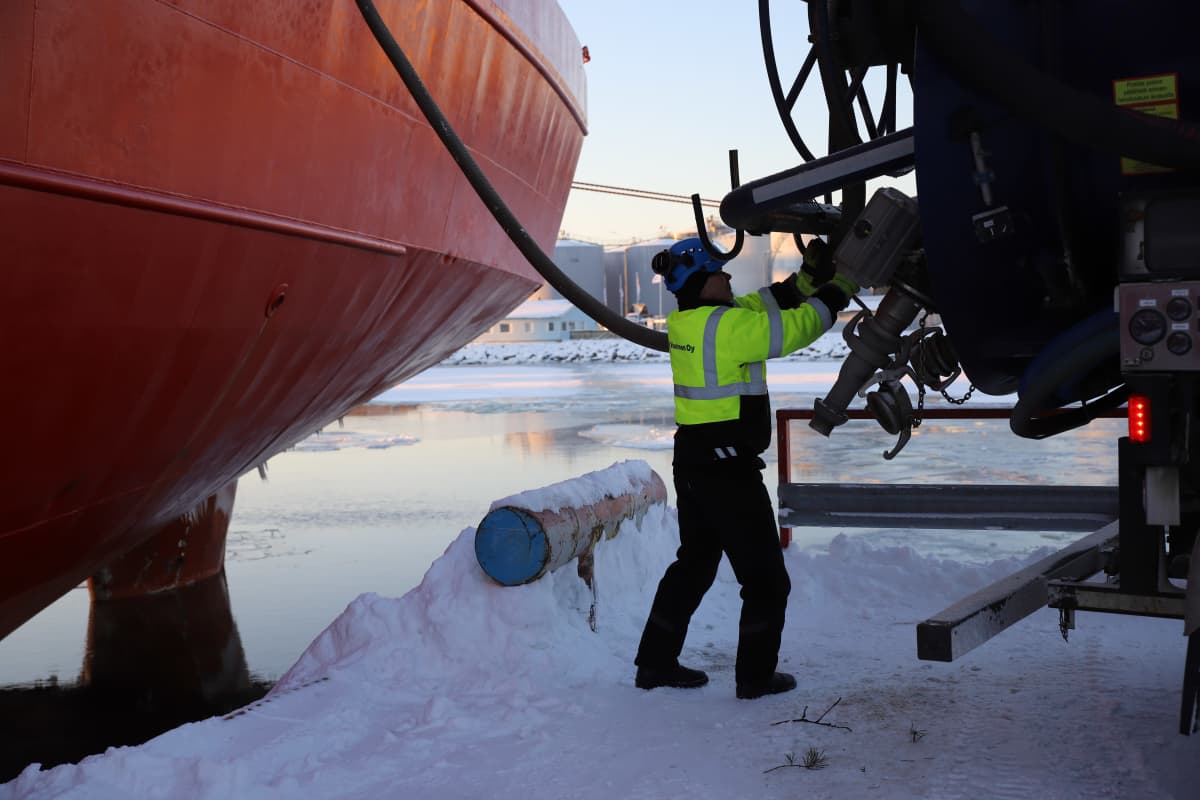 Vuorinen Oy:n työntekijä kiinnittämässä letkua säiliöautoon Hamina Kotkan satamassa rahtilaivan jätevesien tyhjennystä varten.