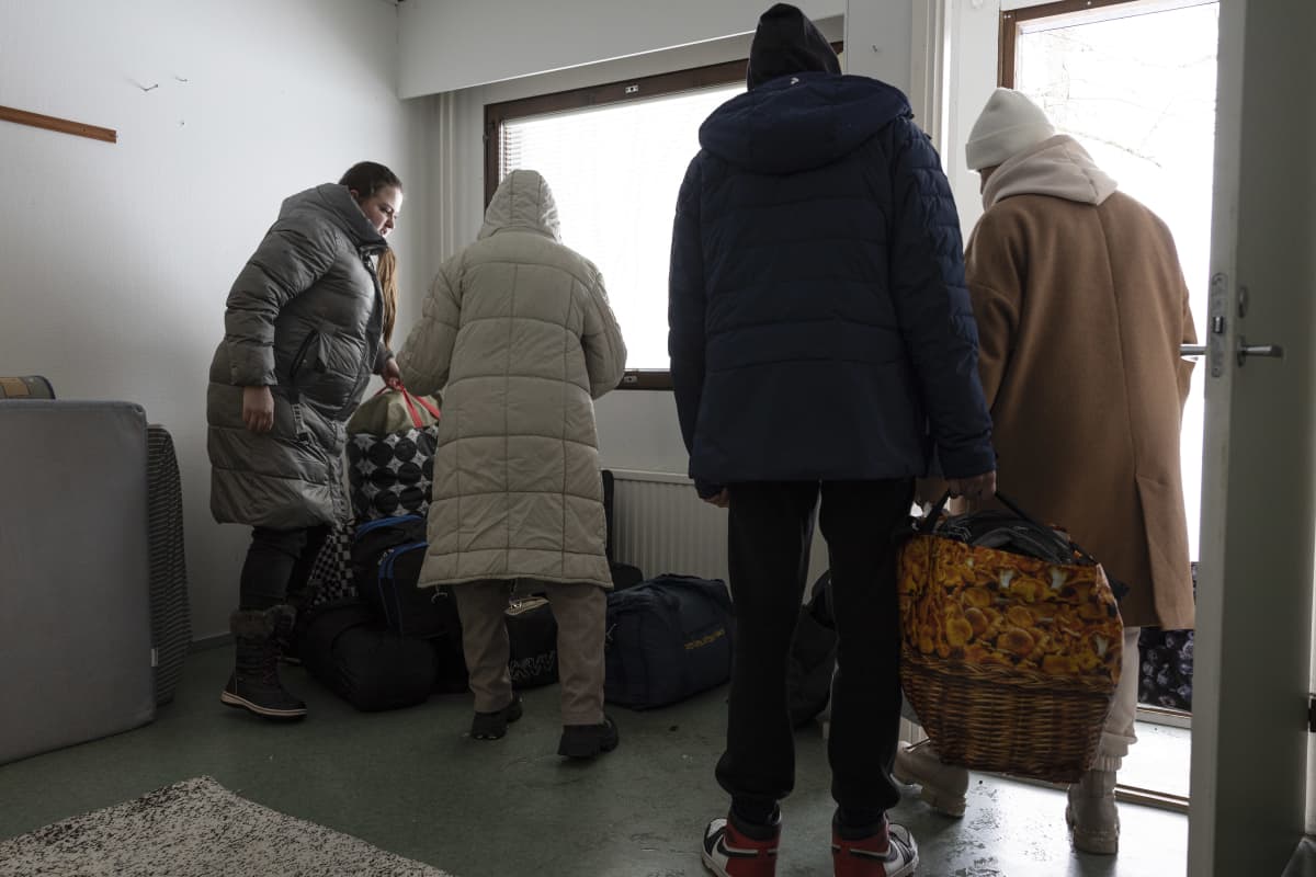 Juuri saapuneet pakolaiset kantavat kasseja huoneeseen Salmirannan vastaanottokeskuksessa Jyväskylässä. 