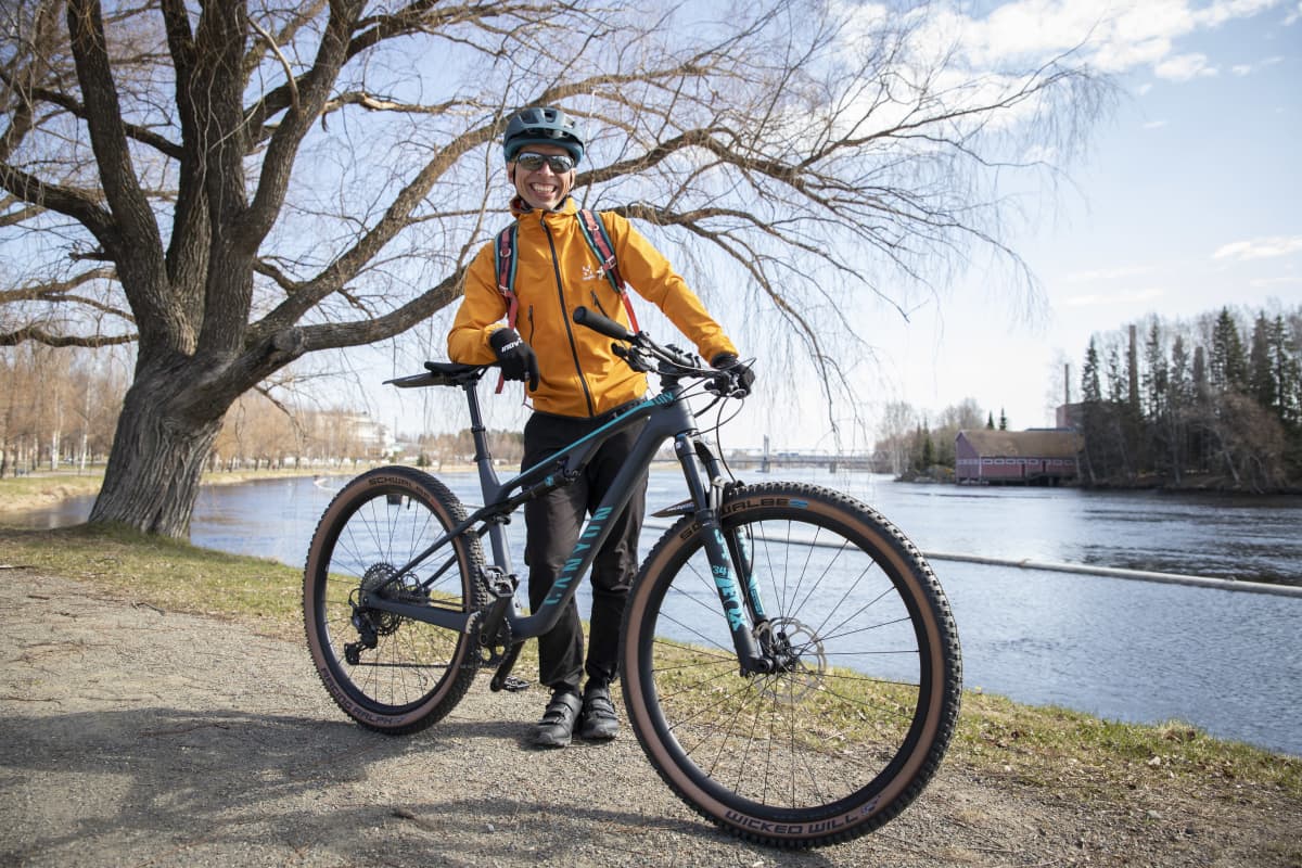 Sami Vartiainen nojaa uuteen pyöräänsä Pielisjoen rannalla.