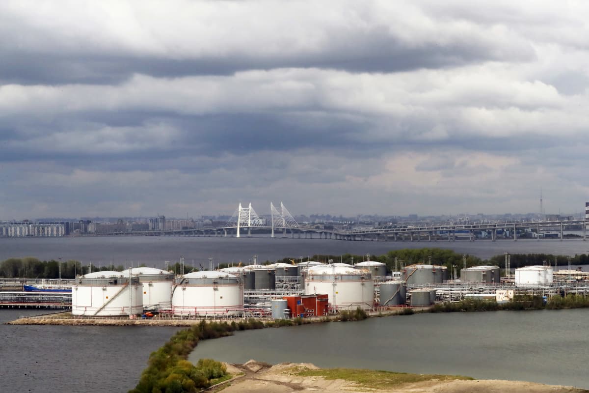 Öljysäiliöitä veden ympäröimällä saarekkeella, taustalla Pietarin kaupunki.