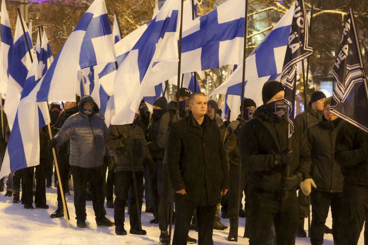 Suomi Herää -kulkue kulkee lumisessa maassa Suomenliput pystyssä.