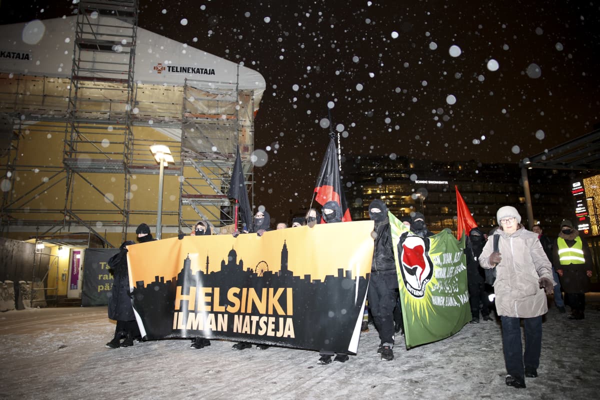 Helsinki ilman natseja -mielenosoitus kulkee lumisateessa.