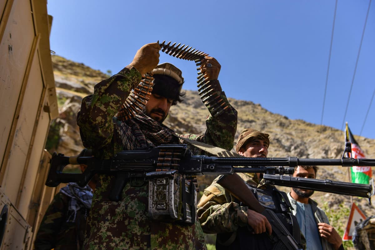 Anti-Taliban vastarintataistelija riisuu konekiväärin ammuksia hartioilta.