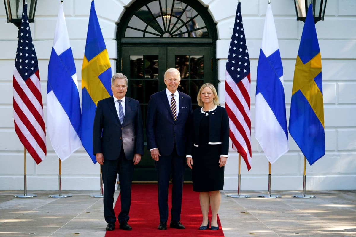 Sauli Niinistö, Joe Biden ja Magdalena Andersson seisovat oven edessä. Taustalla Yhdysvaltain, Suomen ja Ruotsin liput.