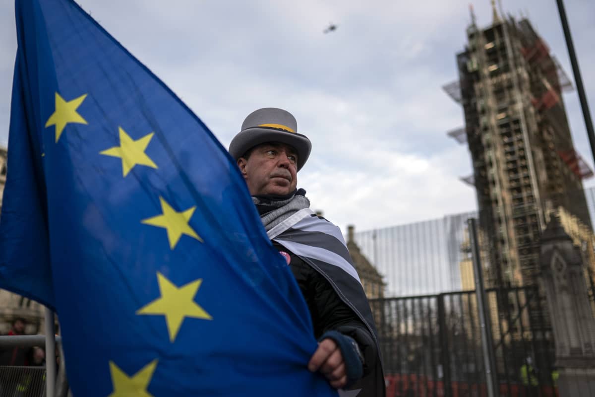 EU-lippua pitelevä mies Britannian parlamentin edustalla.
