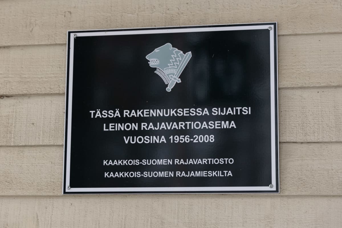 Kyltti Leinon vanhan rajavartioaseman seinässä: "Tässä rakennuksessa sijaitsi Leinon rajavartioasema vuosina 1956-2008".