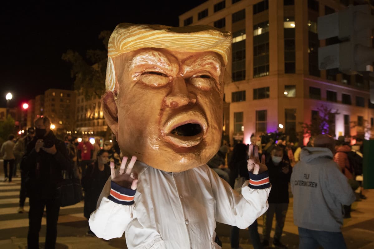 Mielenosoittaja kantoi Washingtonin keskustassa tiistai-iltana Trumpia esittävää päätä.
