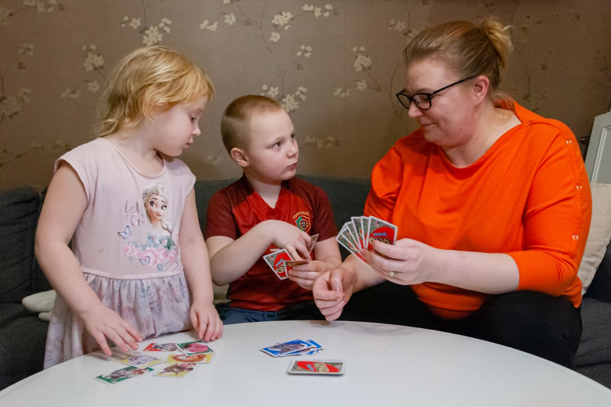 Nina Laine pelaa lastensa Elli ja Onnin kanssa korttia.