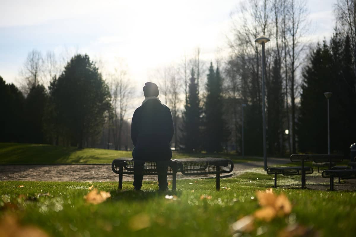  Asperger-diagnoosin saanut Anne istuu puiston penkilllä.