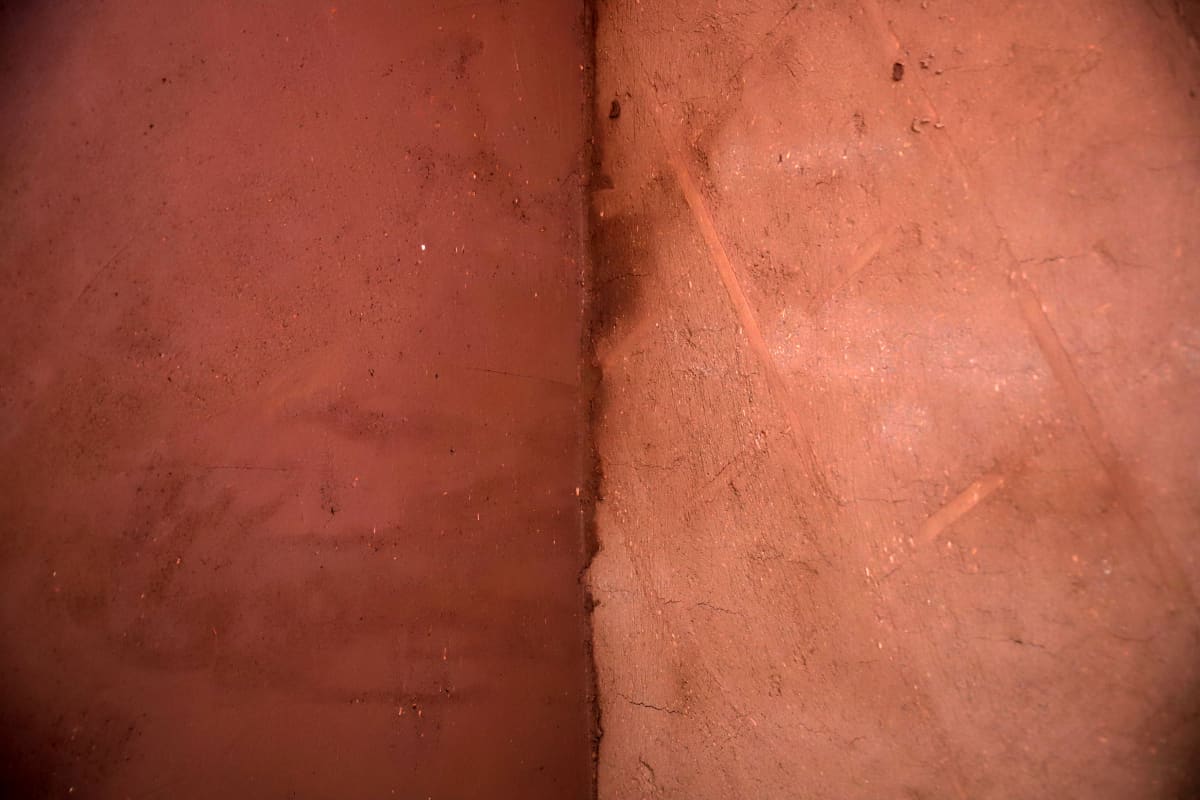 Vasemmalla seinä, joka on saanut päälleen jo kaksi kerrosta savipintaa. Oikealla kaksi viikkoa aikaisemmin laitettu ensimmäinen kerros savea, alla näkyy vielä listoitusta.